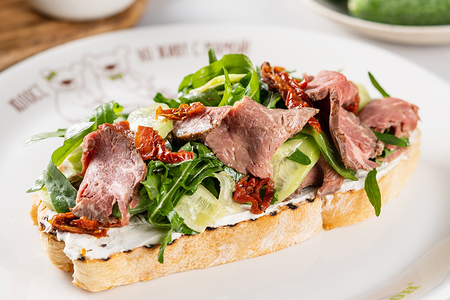 Брускетта с домашним ростбифом, сливочным сыром, листьями салата и огурцом