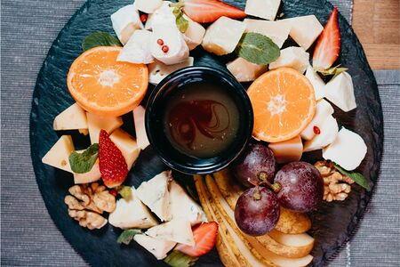 Тарелка сыров с медом душистым и сезонными фруктами и ягодами