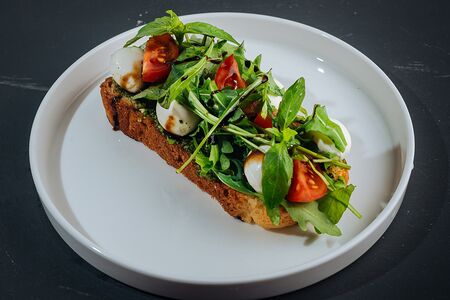 Брускетта с моцареллой, томатами и соусом песто