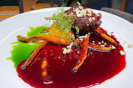 Утка с соусом из смородины с жареными яблоками и молодой морковью