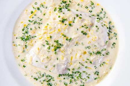 Филе судака, приготовленное с луком-пореем и соусом из белого вина