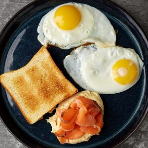 Яичница с хумусом, семгой и хлебом бриошь