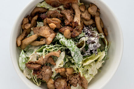 Листья зеленого салата с обжаренной курицей и потрошками