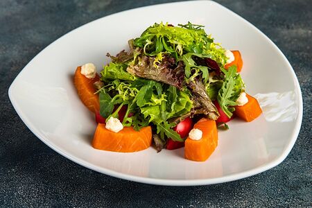 Салат из копченого лосося с листьями салата и помидорами