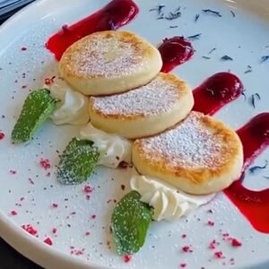 Сырники с клюквенно-малиновым кули и сливочным муссом