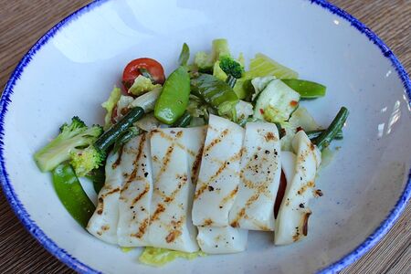 Салат с грилированным кальмаром на хрустящем миксе овощей