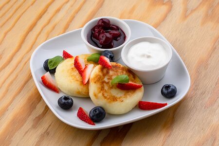 Сырники со сметаной и соусом из ягод
