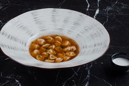 Пельмени в мясном бульоне с копченой сметаной