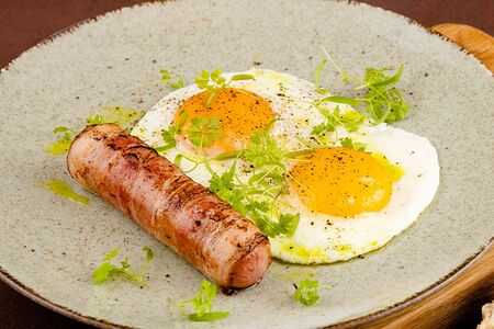 Глазунья из яиц с сосиской в беконе