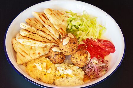 Пита на тарелке с фалафелем