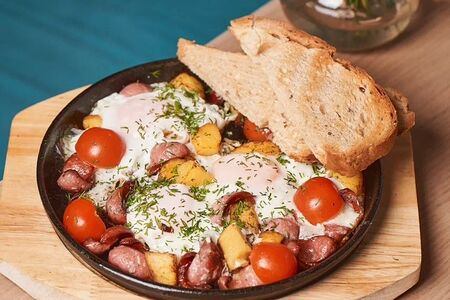 Яичница из трех яиц с колбасками, томатами и картофелем