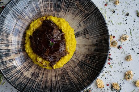 Щеки молодого бычка с пшенной кашей и крепким мясным соусом