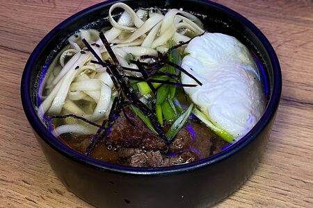 Рамен с жареной говядиной, лапшой удон, яйцом пашот и соленым арахисом