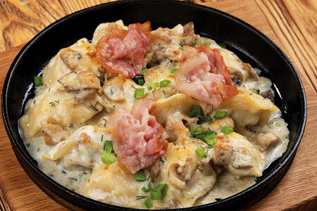 Вареники с картофелем, запеченные под соусом с грибами