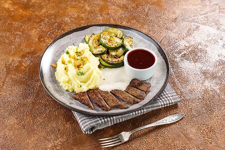 Половина стейка из говядины с картофельным пюре и цукини