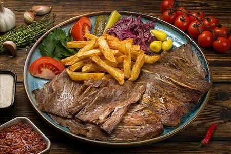 Донер из говядины на тарелке с картофелем фри