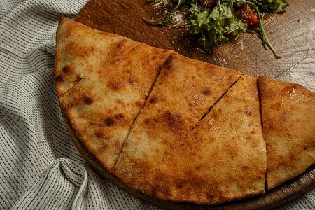 Закрытая пицца кальцоне с ветчиной и грибами