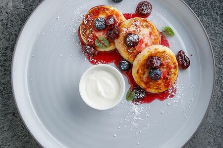 Сырники с вишневым соусом и сметаной