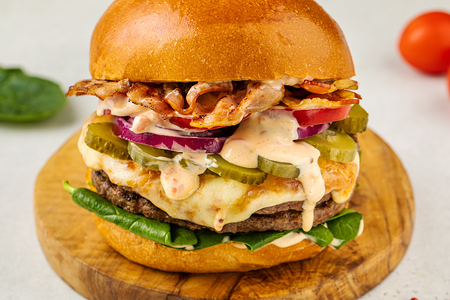 Бургер с двойной котлетой, жареным беконом, маринованным огурцом