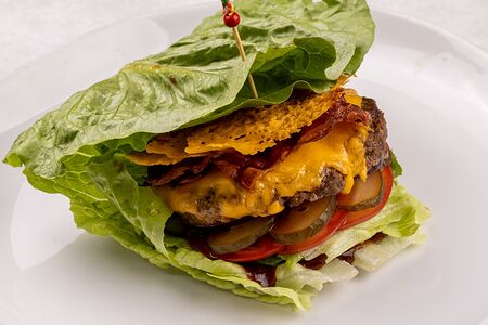 Фирменный Гранд бургер в листьях салата