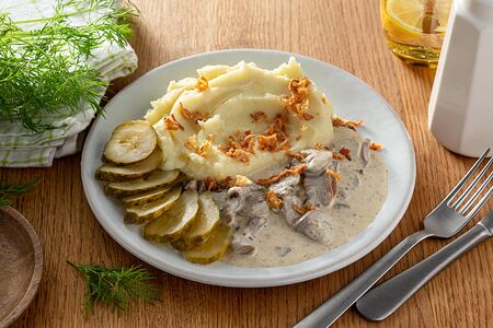 Картофельное пюре с грибной заливкой, луком фри и маринованными огурчиками