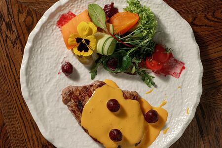 Стейк из свинины, пробитый вишней и чесноком под сырным соусом