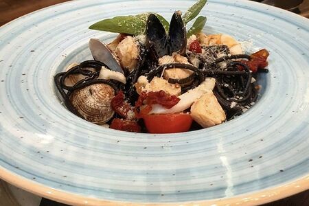 Черные спагетти с морепродуктами и вялеными томатами