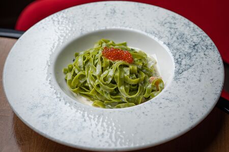 Зеленые тальятелле с лососем и красной икрой