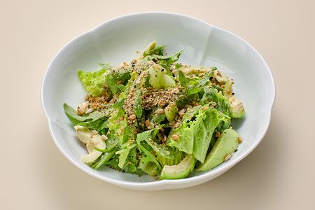 Листья салата с дроблеными семенами, авокадо и лимонным дрессингом