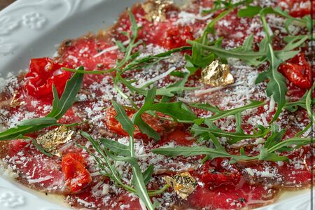 Карпаччо из говядины в маринаде ким чи с рукколой и вялеными томатами