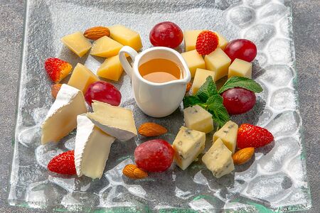 Тарелка благородных сыров со свежей клубникой