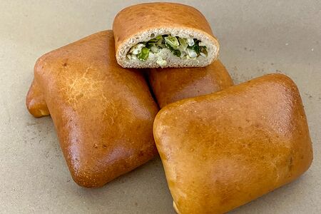 Пирожок ручной работы с зеленым луком и яйцом