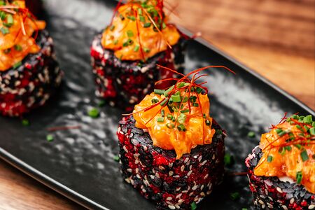 Черный ролл с икрой тобико и спайси лосось