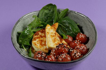 Закуска из томатов севиче с жареным адыгейским сыром, миксом свежей зелени и кунжутом, заправленная соусом понзу