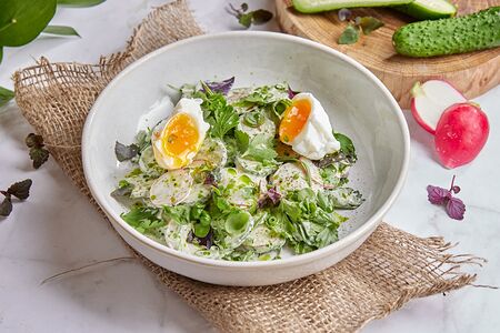 Деревенский салат с огурцом, зеленью и яйцом пашот