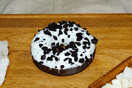 Пончик-донатс с ванильной начинкой, белой глазурью и кусочками печенья