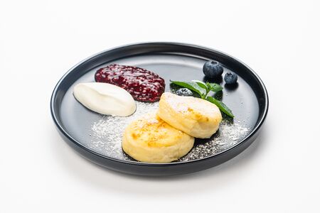 Два сырника с малиной и сметаной