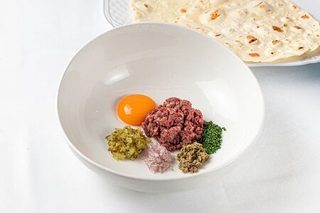 Тартар из мраморной говядины с соусом на основе куриного желтка