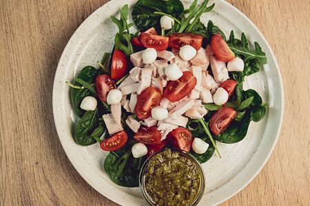 Салат с куриной грудкой, черри и моцареллой под соусом песто