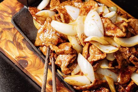 Говядина с луком на сковороде