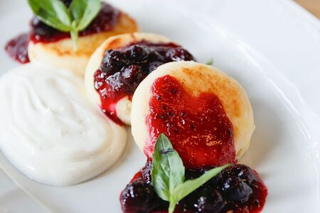 Сырники из рикотты со сметаной и черной смородиной