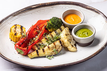 Овощи на гриле с соусами пряные травы и ромеско