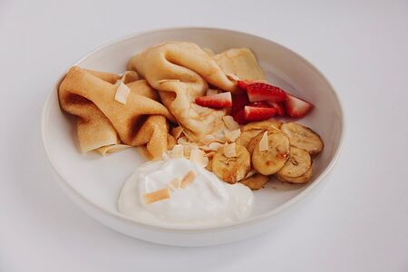 Блинчики с кокосовым кремом, клубникой и карамелизированным бананом