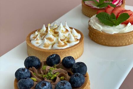 Ассорти из 4 тартов: шоколадный с голубикой, лимонный с меренгой фламбэ, ванильный с клубникой и вишнёвый