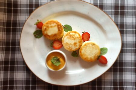 Сырники с апельсиновой цедрой и облепиховой сметаной