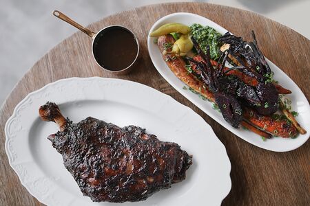 Томленая лопатка ягненка, чернослив и корнеплоды на углях