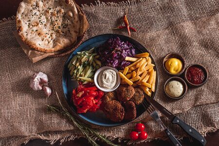 BBQ Фалафель с овощами и соусом на тарелке