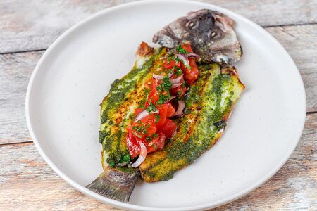 Запеченный сибас с песто и томатами