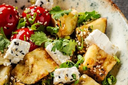 Теплый салат с хрустящими баклажанами, спелыми томатами, кинзой и сыром фета