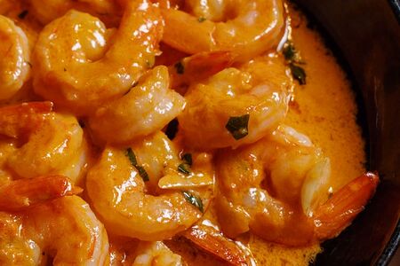 Креветки, обжаренные в соусе, с базиликом, томатами, чесноком и травами